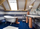 Dominantou velkorysé koupelny v modrobílém provedení je vana na noikách v