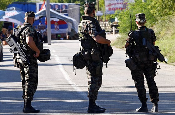 Slovintí vojáci v misi KFOR obhlíejí barikádu, kterou Srbové postavili u
