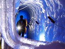 Mu s pochodní prochází pírodním ledovým palácem v horském ledovci Hintertuxer