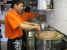 Kuchař připravuje polévkus velkými kusy hovězího ve vitenamském bistru Pho