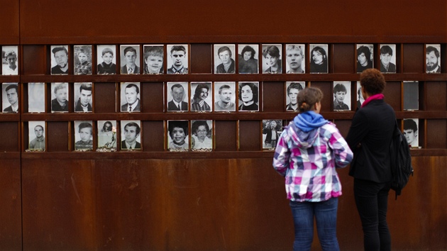 Návtvníci památníku berlínské zdi si prohlíí portréty lidí, kteí zahynuli