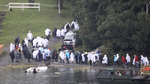 Příbuzní obětí masakru procházejí po ostrově Utoya a vzpomínají na své blízké, kteří tam zemřeli. (19. srpna 2011) 
