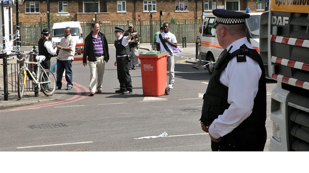 Lidé diskutují s policisty na Tottenham High Road na severu Londýna (10. srpna...