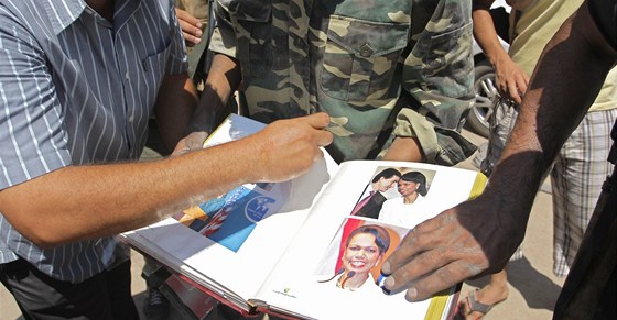 Povstalci si prohlíí Kaddáfího album s Condoleezzou Riceovou. (25.srpna 2011)