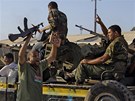 Libyjtí rebelové se radují u dobytého komplexu Báb al-Azízíja, který patil...