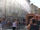 Kropící vz osvuje lidi na Staromstském námstí v Praze.