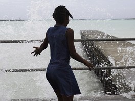 Dívka si hraje ve sprkách rozboueného moe v Nassau na ostrov New
