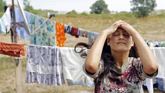 Romská dívka si upravuje vlasy v nelegálním táboe poblí Nantes.