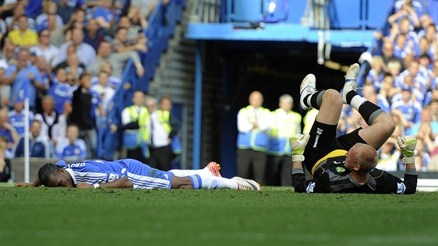 Didier Drogba z Chelsea (vlevo) leí v bezvdomí na trávníku.