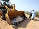 Dobrovolníci vykopávají tla afrických Kaddáfího oldák, kteí byli zabiti