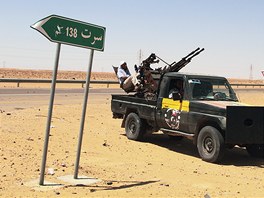 Vozy libyjskch rebel jsou zaparkovan vedle silninho ukazatele na msto