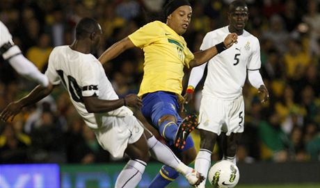 Ronaldinho (ve lutém dresu) pechází pes Kwadwo Asamoaha pi pátelském