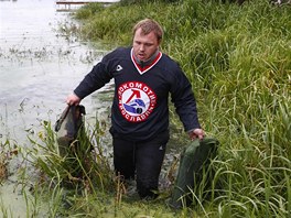 P�íznivec hokejového klubu Lokomotiv Jaroslavl prohledává vodu u místa, kde se...