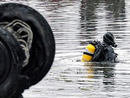 Policejní potápi pátrají po obtech letecké katastrofy. (7. záí 2011)