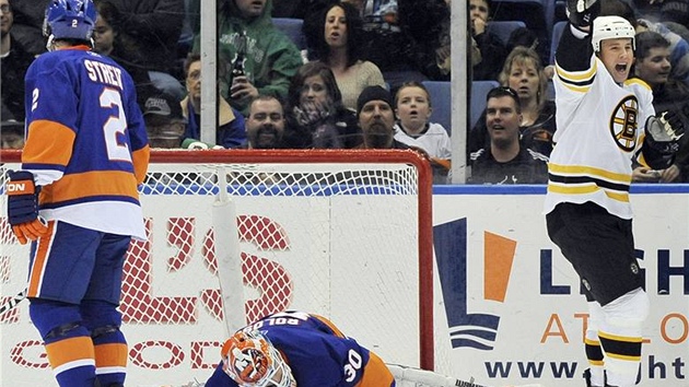 Marc Savard z Bostonu zvedá hokejku nad hlavu a oslavuje. To pokoenému