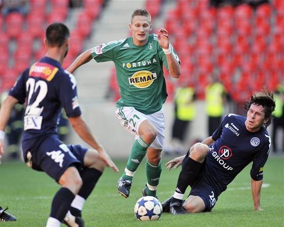 ODVÁNÝ PRNIK. Milan koda z Bohemians 1905 (v zeleném) se snaí projít mezi