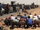 Libyjtí povstalci se modlí pi cest k Baní Válid (15. srpna 2011)