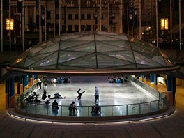 Skupina mladých lidí za soumraku zkouí break dance na námstí Robson ve