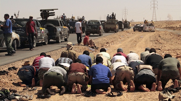 Libyjtí povstalci se modlí pi cest k Baní Válid (15. srpna 2011)