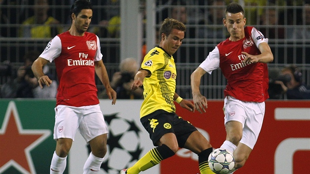 Dortmundský fotbalista Mario Götze se snaí prosadit mezi  Mikelem Artetou...