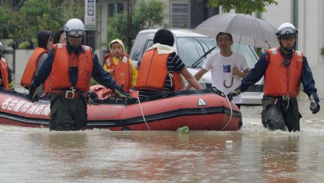 Záchranái evakuují rodinu v zatopeném mst Nagoja.