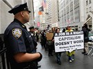 Protestující s transparenty pochodují po Wall Streetu u týden (20. záí 2011)
