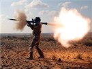 Libyjský povstalec stílí z runího protitankového granátometu (RPG) na vojáky...