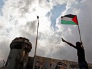Mladý mu s palestinskou vlajkou demonstruje u hraniního pechodu Calandia