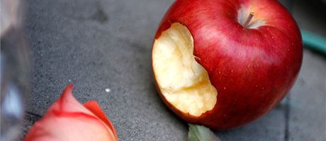 Nakousnuté jablko, pipomínající slavné logo Applu leí spolu s kvtinami ped