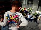 Chlapec se dívá na kvtiny u obchodu Apple v ínském Pekingu. (6. íjna 2011)
