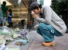 Satoko Sakaiová se modlí ped obchodem Shibuya Apple v centru Tokia. (6. íjna