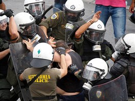 etí policisté bijí mue, který se úastní demonstrace na athénském námstí