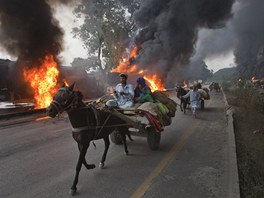 Pákistánec popohání svého kon, aby co nejrychleji zmizel od hoících tanker s