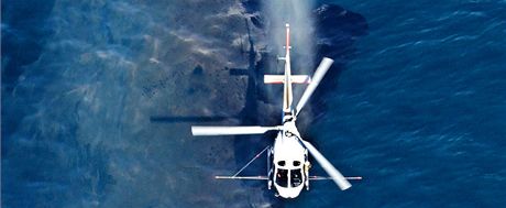Novozélandtí záchranái stíkají z vrtulníku disperzní látku na olejovou