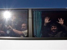 Palestinci proputní z izraelských vznic mávají z autobusu provázeného...