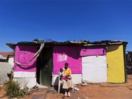 Nemukula Shonisayiová s dítětem před svou chýší u Johannesburgu.