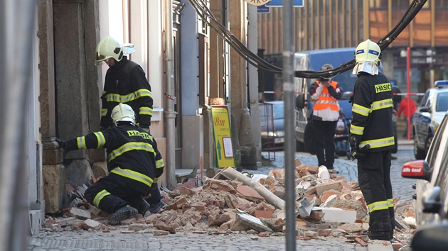 Hasiči prohlížejí sutiny u domu v centru Olomouce, jehož zeď se zřítila.