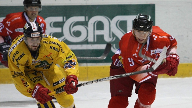 Olomoucký hokejista Jakub �laha� (v �erveném) bojuje o puk se �umperským