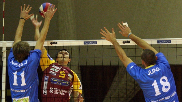 Liberecký volejbalista Martin Tichá�ek (uprost�ed) sme�uje p�es ústecké Filipa