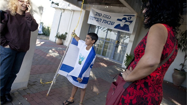 Izraelský chlapec se omotává izraelskou vlajkou v centru vesnice Mitzpe Hilla,