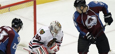 Chicagsk brank Corey Crawford hld puk ped Milanem Hejdukem a Danielem