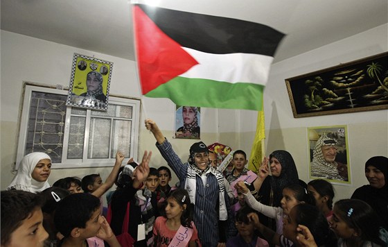 Wafa al-Bissová tímá palestinskou vlajku ve svém dom po proputní z izraelského vzení. Vítala ji rodina, pátelé i koláci. (19. íjna 2011)