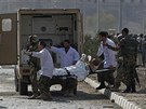 Vojáci odváí zranného amerického vojáka z místa výbuchu v Kábulu.