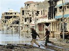 Vojáci libyjské Pechodné národní rady bí ulicí rozbombardovaného Kaddáfího