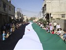 Syané protestují proti reimu Baára Asada s obí syrskou vlajkou na pedmstí
