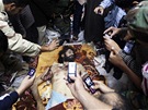 Libyjci si v Misurát fotografují tlo Mutasima Kaddáfího. (21. íjna 2011)