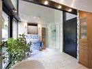 Koupelnu v podkroví osvil modrobílý mozaikový obklad a teplé tóny bukového