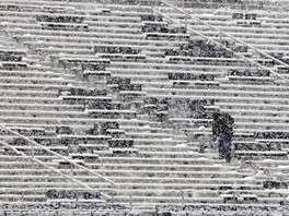 Uklíze oprauje sníh ze sedaek na Beaver stadionu v Pensylvánii. V Allentownu