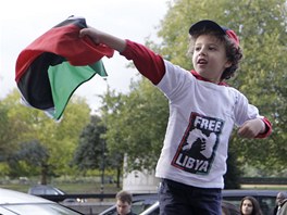 Malý chlapec mává libyjskou vlajkou ped velvyslanectvím zem svých pedk ve