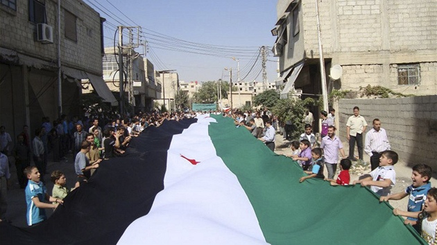 Syané protestují proti reimu Baára Asada s obí syrskou vlajkou na pedmstí